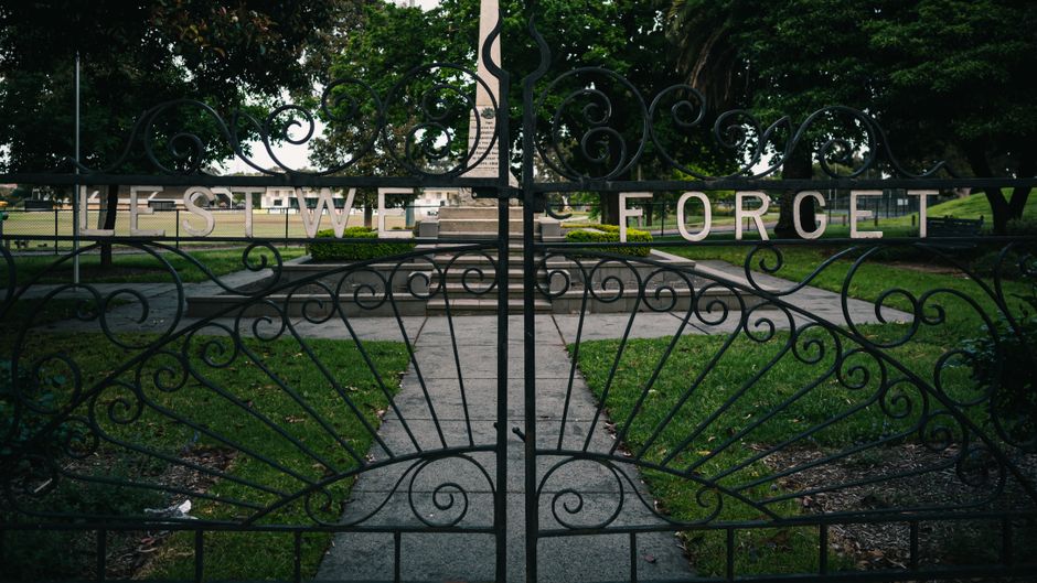Ornate iron gate set in a quiet park.