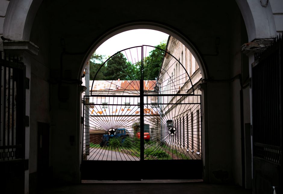 View through a decorative metal gate towards a courtyard